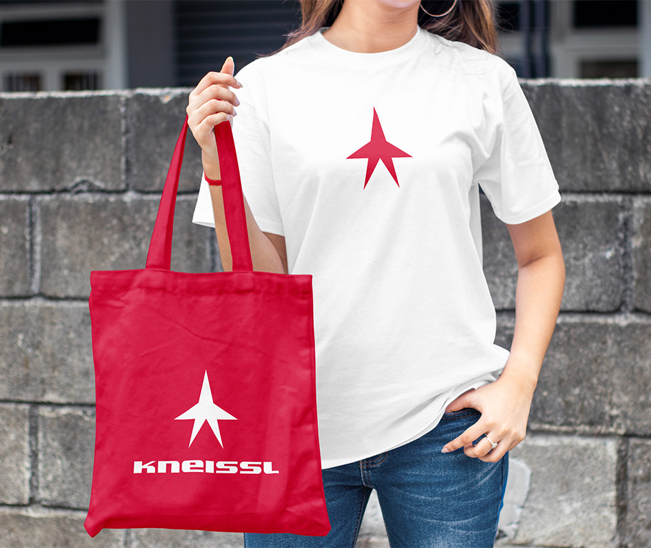 Kneissl apparel image of white t-shirt and red tote bag